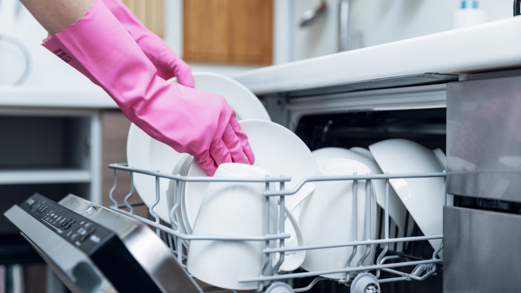 Housewife taking out clean dishware from dishwasher at home kitchen picture id903658124
